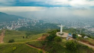 Stunning aerial view of Cristo Rey statue overlooking Cali's cityscape in Colombia.