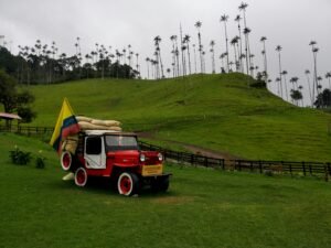 A vintage jeep with Colombian flag in the lush green hills of Salento, Colombia.