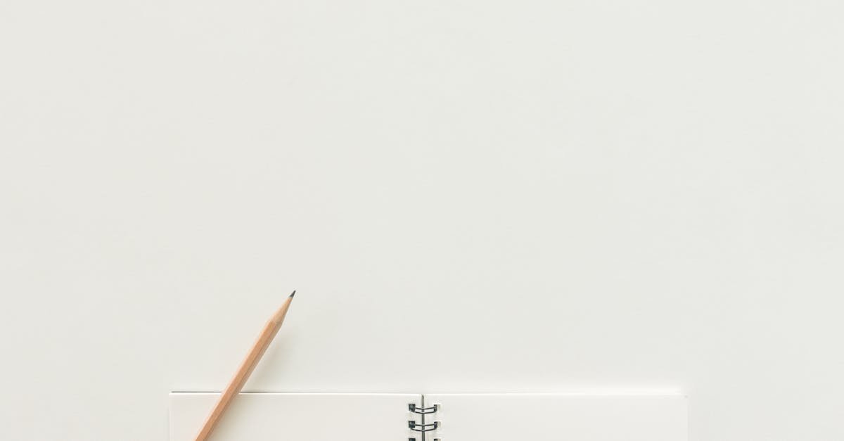 A top view of a spiral notebook with pencil on a neutral light background, ideal for creative workspaces.