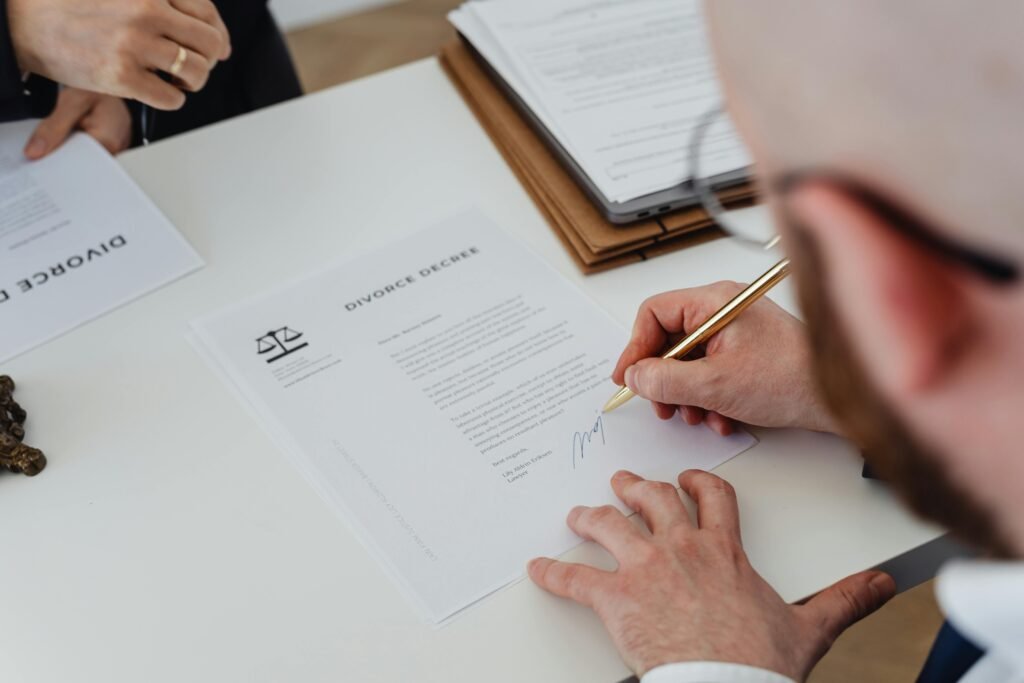 commercial-plumbing Close-up of a person signing a divorce decree on a desk.