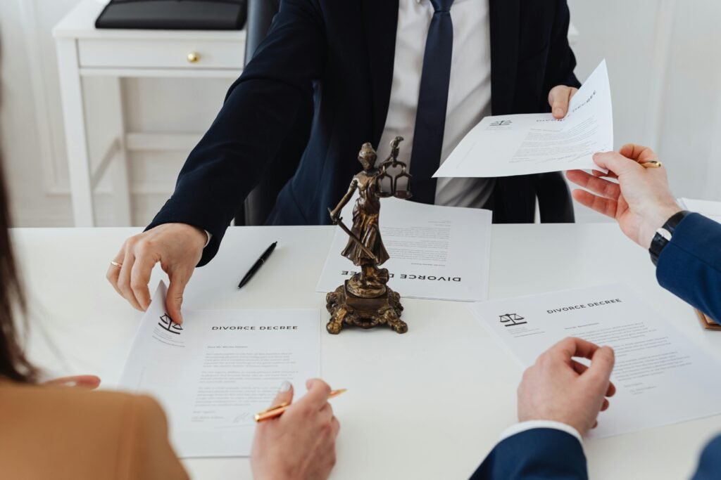 gas-pipeline Three adults discussing divorce documents in a formal office setting with legal statue in view.